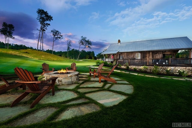 yard at dusk featuring a patio and a fire pit