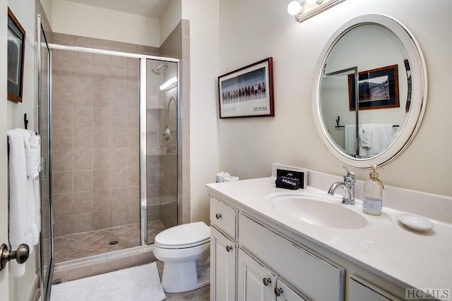 bathroom with tile patterned floors, vanity, toilet, and walk in shower