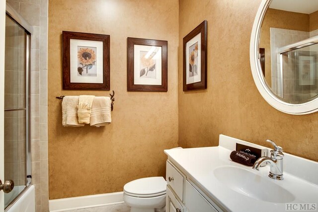 full bathroom featuring combined bath / shower with glass door, vanity, and toilet