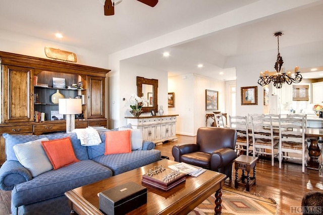 living room featuring dark hardwood / wood-style flooring and ceiling fan with notable chandelier