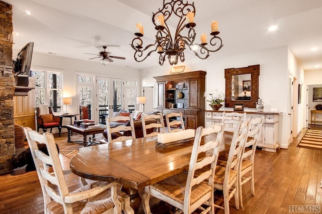 dining room with ceiling fan with notable chandelier and light hardwood / wood-style flooring