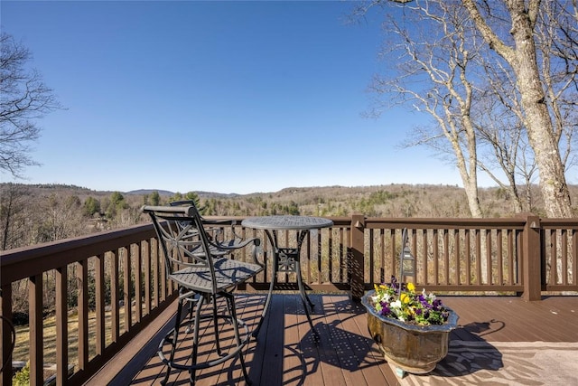 wooden terrace featuring a view of trees