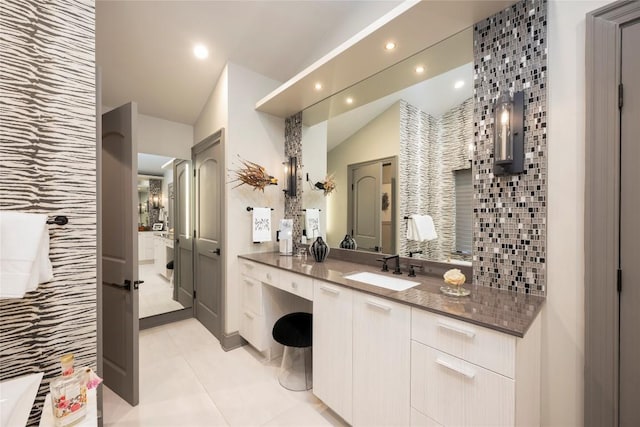 bathroom with vanity, recessed lighting, tile patterned flooring, vaulted ceiling, and backsplash