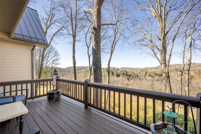 wooden terrace featuring a wooded view