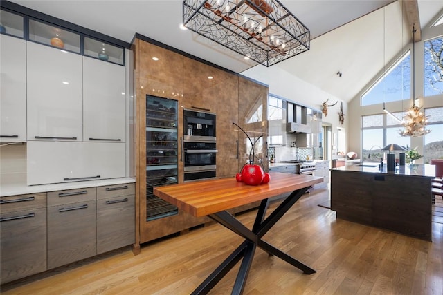 dining area featuring an inviting chandelier, plenty of natural light, and light wood-type flooring