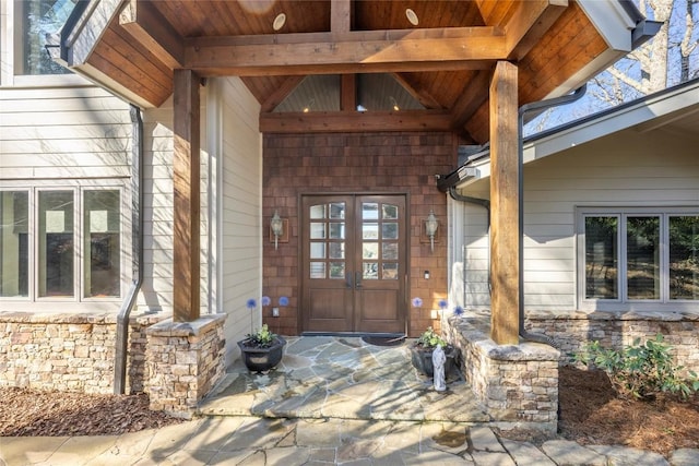 doorway to property featuring stone siding and french doors