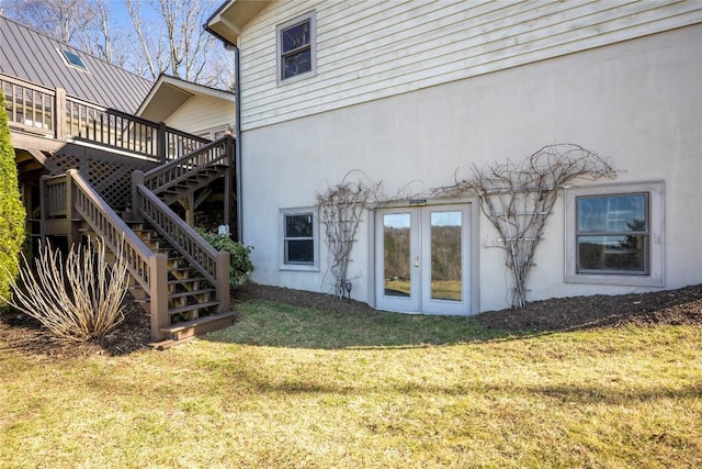 rear view of house with stairway, a yard, a deck, and french doors