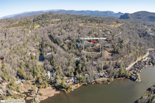 aerial view featuring a forest view and a water and mountain view