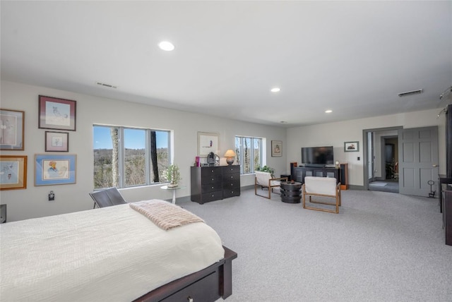 carpeted bedroom featuring multiple windows, recessed lighting, and visible vents