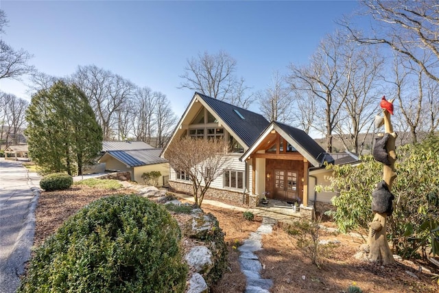 view of front of home featuring metal roof and stone siding