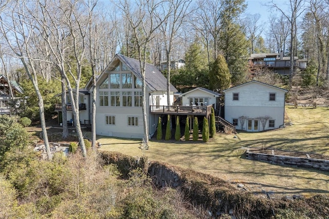 rear view of property featuring stairway, a lawn, and a wooden deck