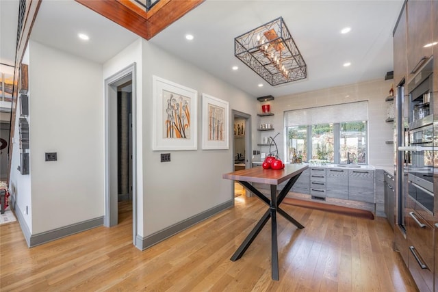 office with light wood finished floors, recessed lighting, baseboards, and a sink