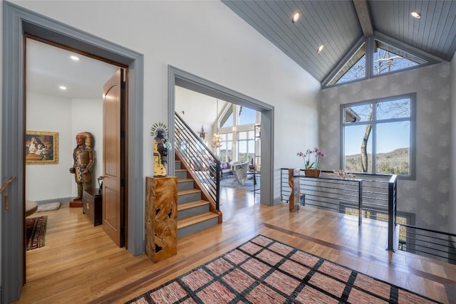 foyer featuring beam ceiling, plenty of natural light, and light wood-type flooring