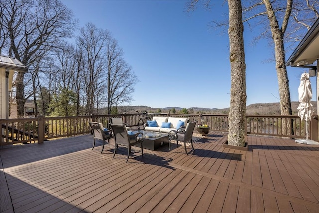 wooden deck featuring a mountain view and an outdoor hangout area