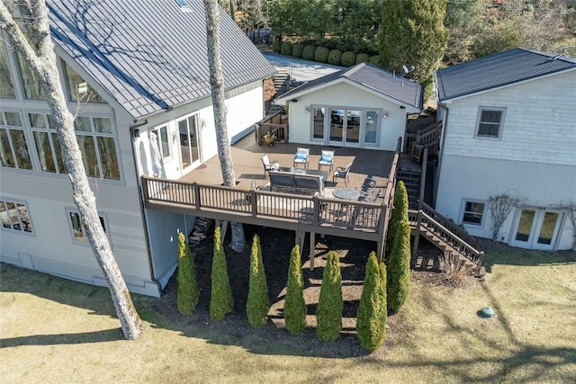 rear view of property with stucco siding, stairs, and a deck