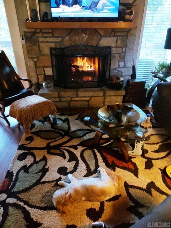 369 Meadow Way Unit 1713, Sapphire, NC 28774 - living area with a stone fireplace, plenty of natural light, and wood finished floors