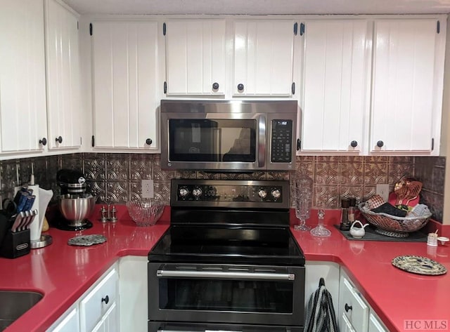 369 Meadow Way Unit 1713, Sapphire, NC 28774 - kitchen with electric range, stainless steel microwave, decorative backsplash, and white cabinetry