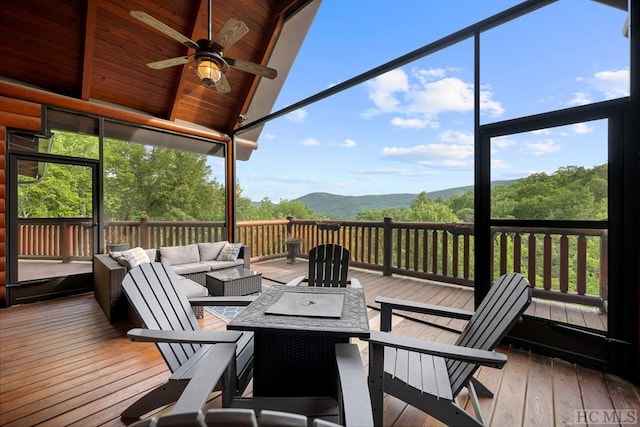 wooden deck featuring ceiling fan, a mountain view, and an outdoor living space with a fire pit