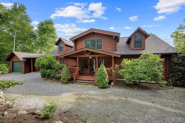 log cabin featuring a garage and covered porch