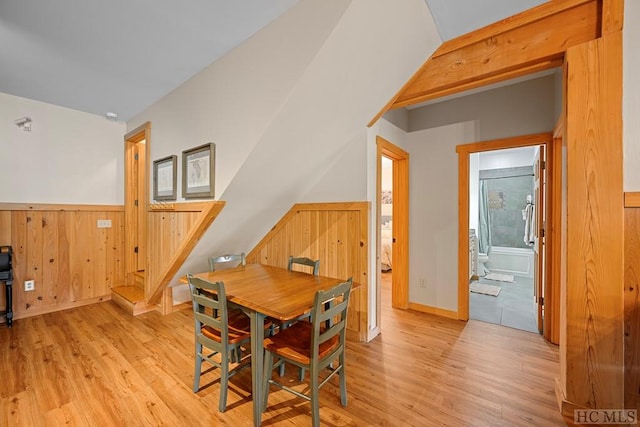 dining area featuring wooden walls and light hardwood / wood-style flooring