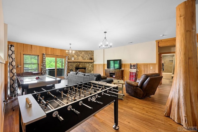 rec room with hardwood / wood-style floors, a fireplace, and wood walls