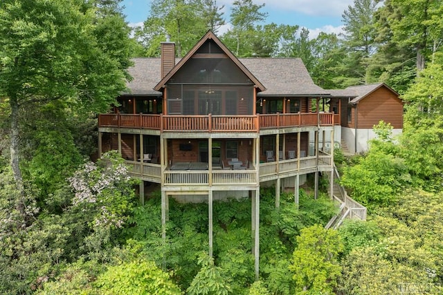 rear view of house featuring a deck and a sunroom