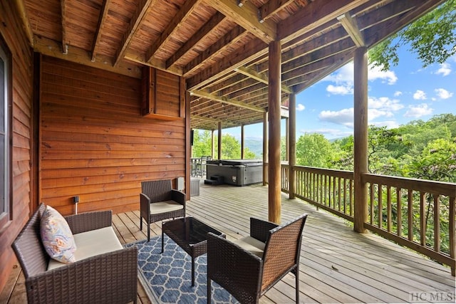 wooden terrace with an outdoor living space and a hot tub