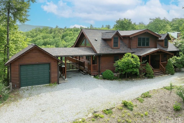 log home with an outbuilding, a garage, and a porch