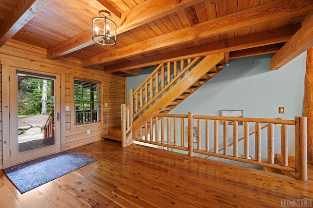 foyer with an inviting chandelier, hardwood / wood-style floors, wood ceiling, and wood walls