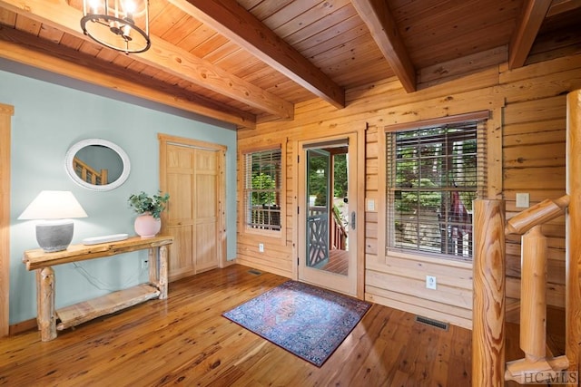 foyer entrance featuring beam ceiling, hardwood / wood-style floors, wood ceiling, and wooden walls