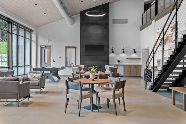 dining room with visible vents, pool table, concrete flooring, high vaulted ceiling, and stairs