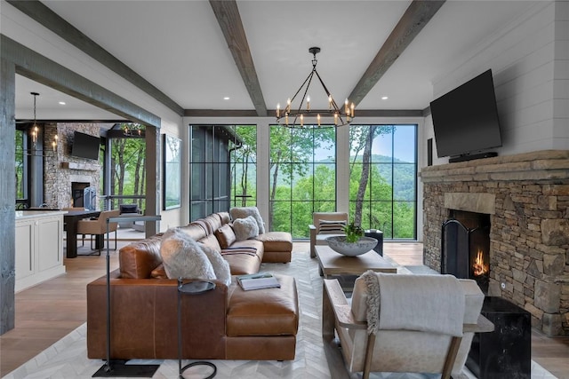 living area with beamed ceiling, a fireplace, and a notable chandelier