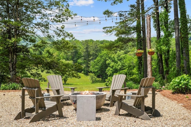view of patio / terrace featuring a fire pit and a forest view