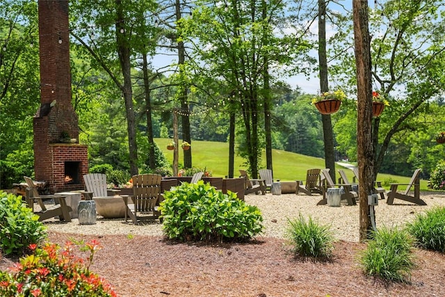 view of yard featuring a patio area and an outdoor brick fireplace