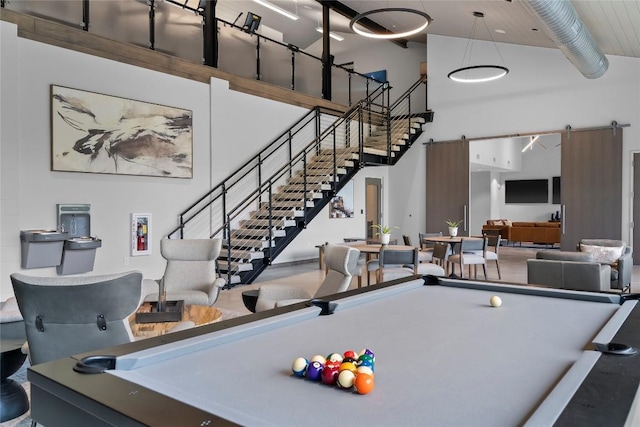 rec room featuring a barn door, billiards, and a towering ceiling