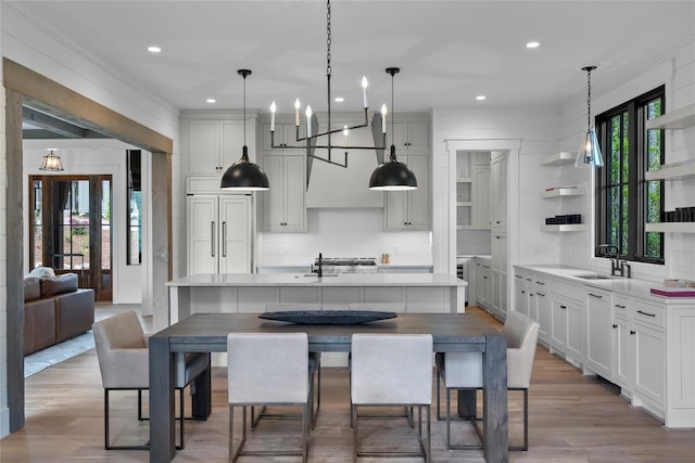 kitchen featuring light countertops, open shelves, a sink, and wood finished floors