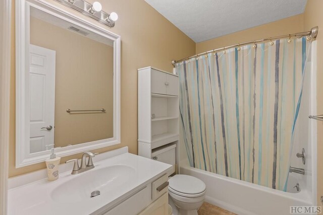 full bathroom featuring vanity, shower / bathtub combination with curtain, a textured ceiling, and toilet