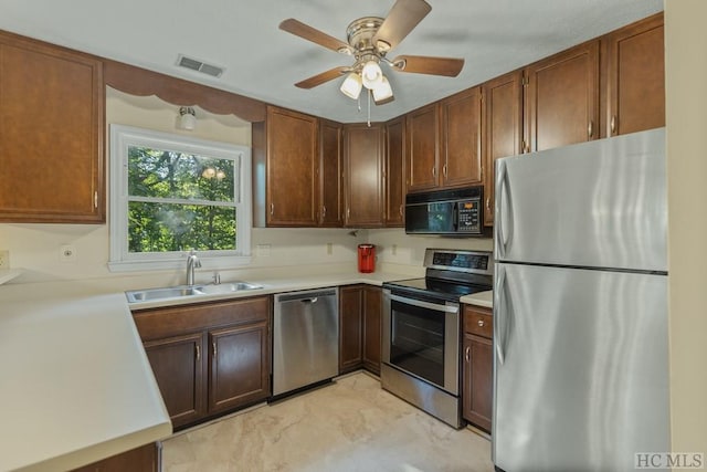 kitchen with appliances with stainless steel finishes, sink, and ceiling fan