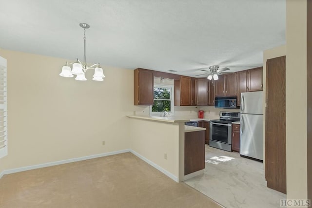 kitchen with appliances with stainless steel finishes, ceiling fan with notable chandelier, decorative light fixtures, light colored carpet, and kitchen peninsula