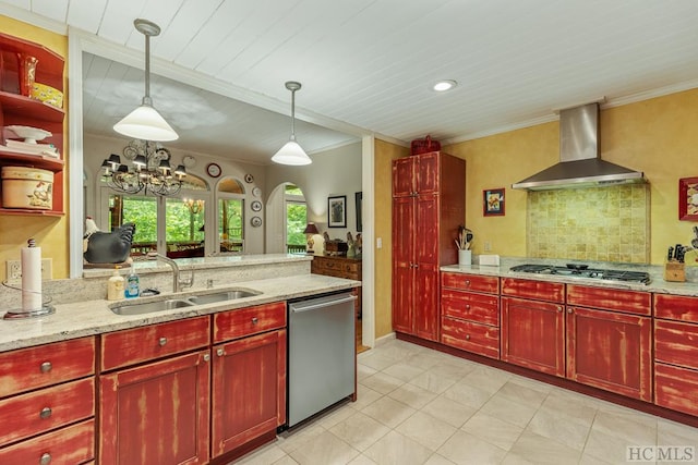 kitchen with appliances with stainless steel finishes, light stone counters, wall chimney range hood, decorative light fixtures, and sink