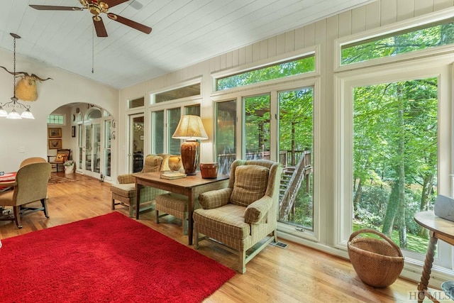 sunroom / solarium with vaulted ceiling, wooden ceiling, and ceiling fan with notable chandelier