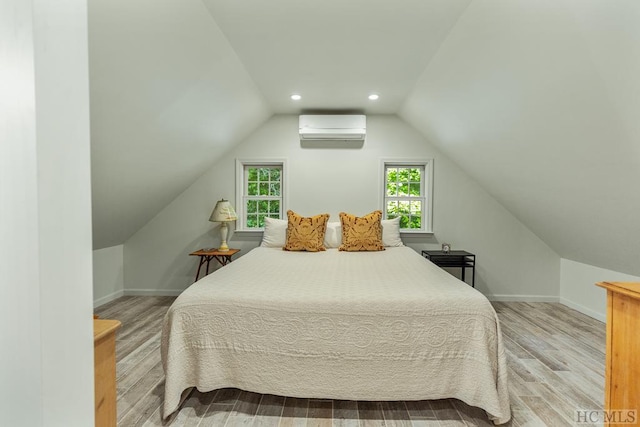 bedroom with light hardwood / wood-style flooring, a wall mounted AC, and lofted ceiling