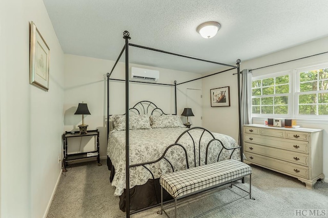 bedroom featuring light carpet, a wall mounted AC, and a textured ceiling