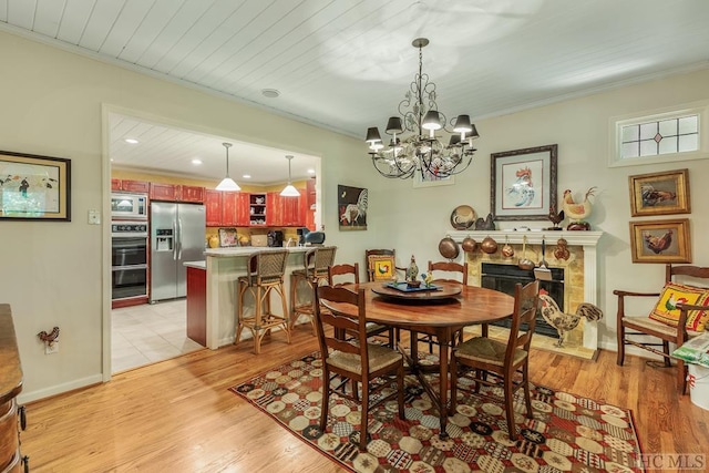 dining area featuring light hardwood / wood-style flooring, wood ceiling, and ornamental molding