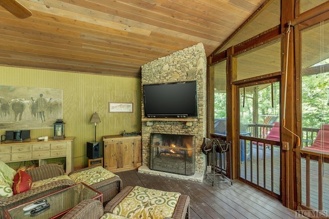 living room featuring hardwood / wood-style floors, vaulted ceiling, wood ceiling, and a stone fireplace