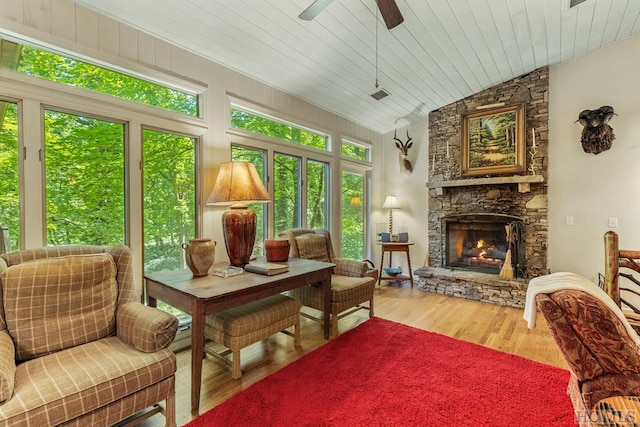 sunroom / solarium featuring a fireplace, vaulted ceiling, ceiling fan, and wood ceiling