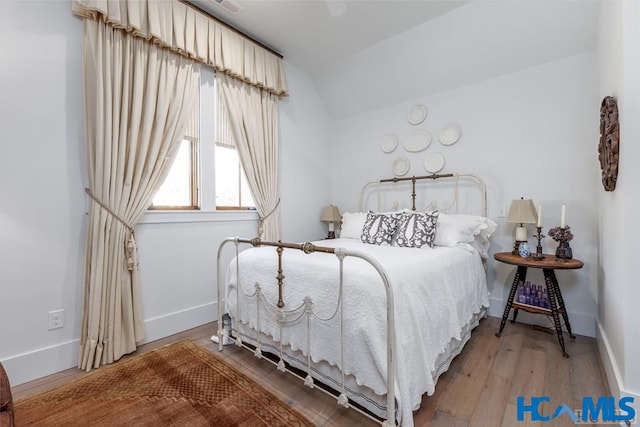 bedroom with vaulted ceiling, baseboards, wood-type flooring, and ceiling fan