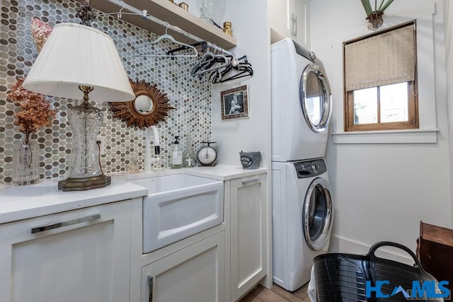 laundry room with a sink, laundry area, and stacked washing maching and dryer