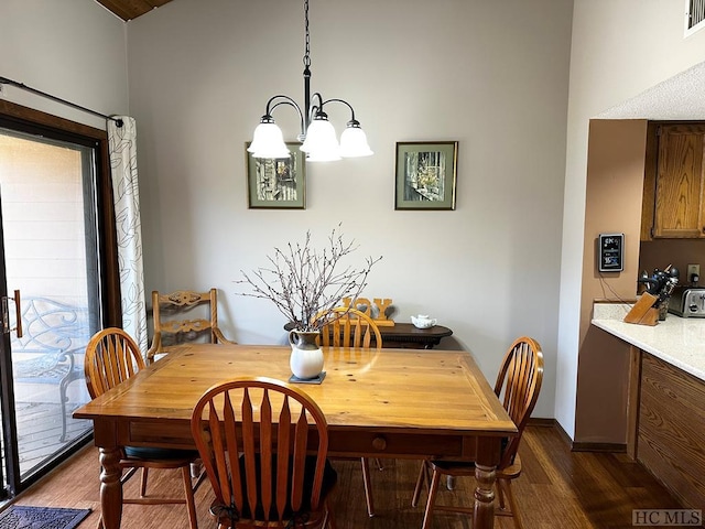 dining area with dark hardwood / wood-style flooring and an inviting chandelier