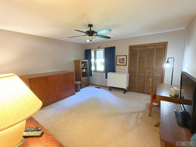 interior space featuring light colored carpet, a closet, and ceiling fan